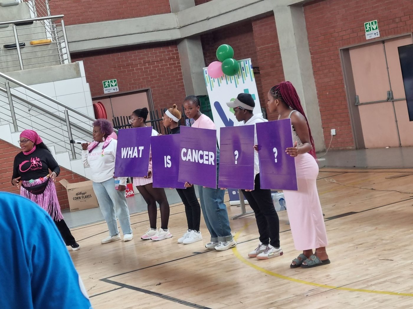 Cancer education session with What is Cancer signage